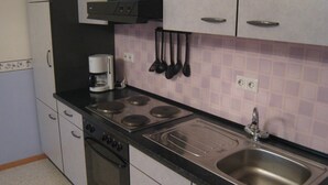 A kitchen with a stove, oven, sink, and coffee maker. - Apartment in Morbach Near Ski Lift (Morbach)