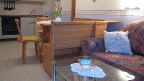 A compact living space with a dining area, a sofa, and a glass-top coffee table. - Apartment in Morbach Near Ski Lift (Morbach)
