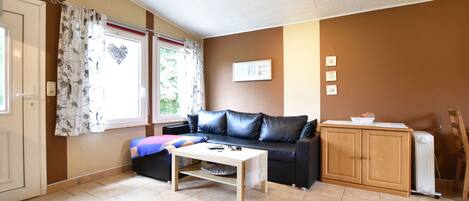 A living room with a sofa, a coffee table, a cabinet, and a radiator.
