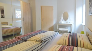 A bedroom with two beds, a mirror, a dresser, and a window. - Beautiful Holdiday Home in Ulmen Near the Lake (Ulmen)