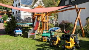A playground with a slide, swings, and toy vehicles. - Apartment in the Hunsruck Region's Drohn Valley (Merschbach)