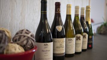 Une rangée de bouteilles de vin est posée sur une table, avec un panier de pain en premier plan.