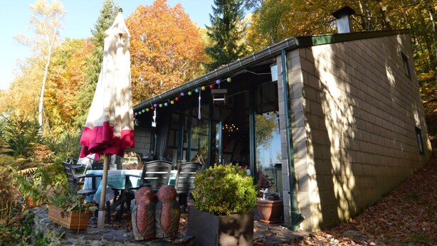 A cozy cabin with a covered porch, outdoor seating, and potted plants. - Amazing Holiday Home in Stavelot With Terrace (Stavelot)