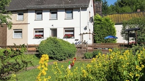 A white building with multiple windows and a garden in the foreground. - Group Stay in Ulmen-furth (Ulmen)