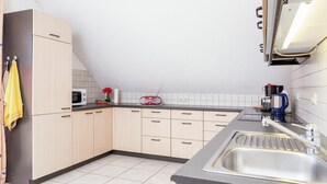 Eine moderne Küche mit Granitarbeitsplatte, Edelstahlspüle und hellen Schränken.