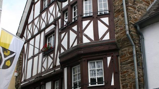 A traditional half-timbered building with multiple windows and a flag. - A Modern Holiday Home for 2-5 People River Mosel (Moselkern)