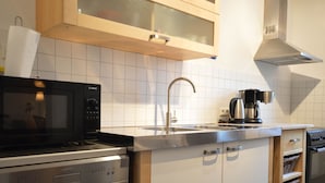 A modern kitchen with a Bosch microwave, stainless steel sink, and a coffee maker. - A Modern Holiday Home for 2-5 People River Mosel (Moselkern)