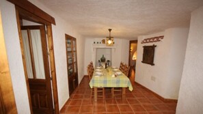 Enjoy meals with family and friends in this dining area, featuring a long table and comfortable seating for four.