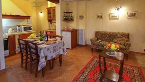 Un salon chaleureux avec un canapé et une table à manger dressée pour le repas.