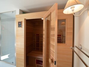 A wooden sauna with a glass door, a control panel, and a towel rack. - Holiday Home in Fays With Sauna & Hiking (Manhay)