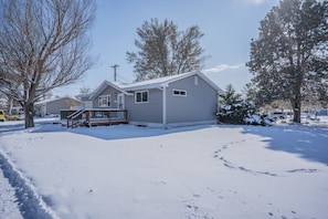 Eenlaags huis met een veranda, garage en een sneeuwbedekte voortuin.