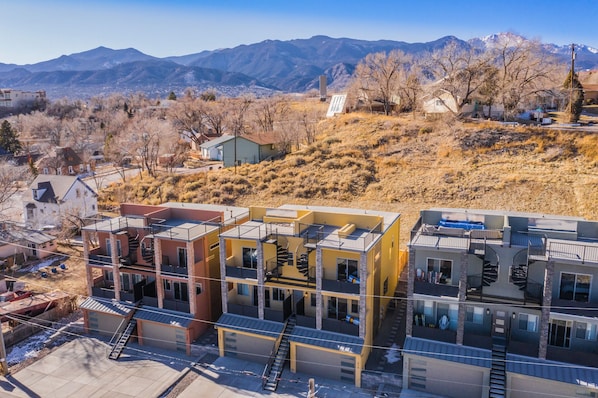 Un edificio residencial de varios pisos con un diseño arquitectónico moderno, que cuenta con varios balcones y una escalera destacada.