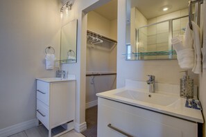 A modern bathroom with two sinks, a glass shower enclosure, and a walk-in shower. - Downtown Skyline Rooftop Patio Modern Townhome (Colorado Springs)