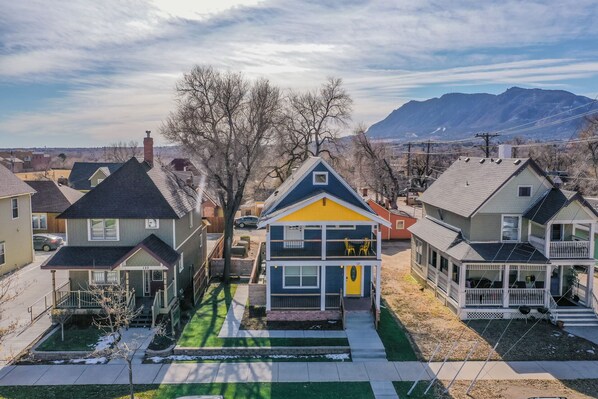 A residential neighborhood with houses, a green lawn, and a mountain in the background.