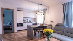 A modern apartment with a kitchen, dining area, and living room. - Ferienhaus mit Sauna in Skigebietsnahe (Drachselsried)