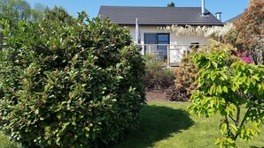 A house with a dark roof, white walls, and a chimney. There is a garden with green bushes and a lawn. - Cottage in Durbuy With Terrace, Garden (Durbuy)