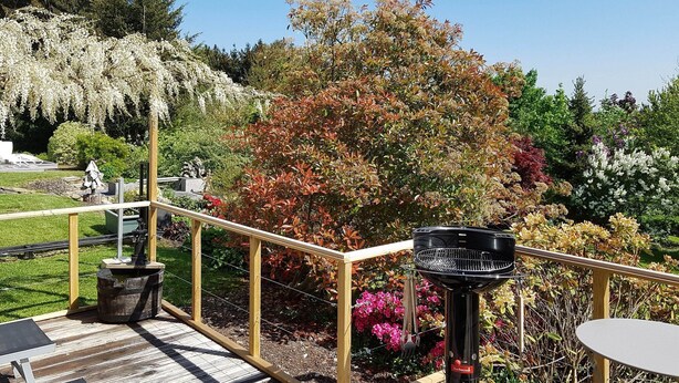 A wooden deck with a grill, a table, and chairs. - Cottage in Durbuy With Terrace, Garden (Durbuy)