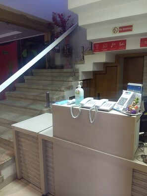 A reception desk with a phone, Paytm card, and a QR code sign. - Hotel Avantika  (Bhopal)