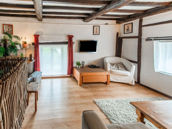 Relax in this inviting living room with a wooden ceiling, comfortable sofa, and large window.