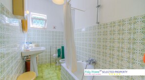 Tina con regadera, secadora de cabello, papel de baño 