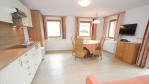 A compact kitchen with a dining area, a TV, and a sofa. - Spacious Apartment in Uderns near Ski Area (Uderns)