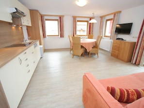 Cozy living space with a kitchenette, dining area, and seating area featuring a sofa and flat-screen TV.