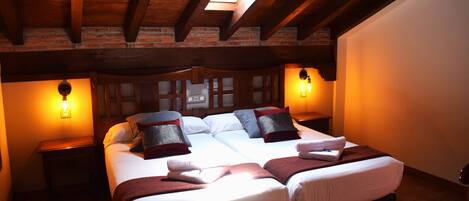 A cozy bedroom with a large bed, two bedside tables, and a skylight above.