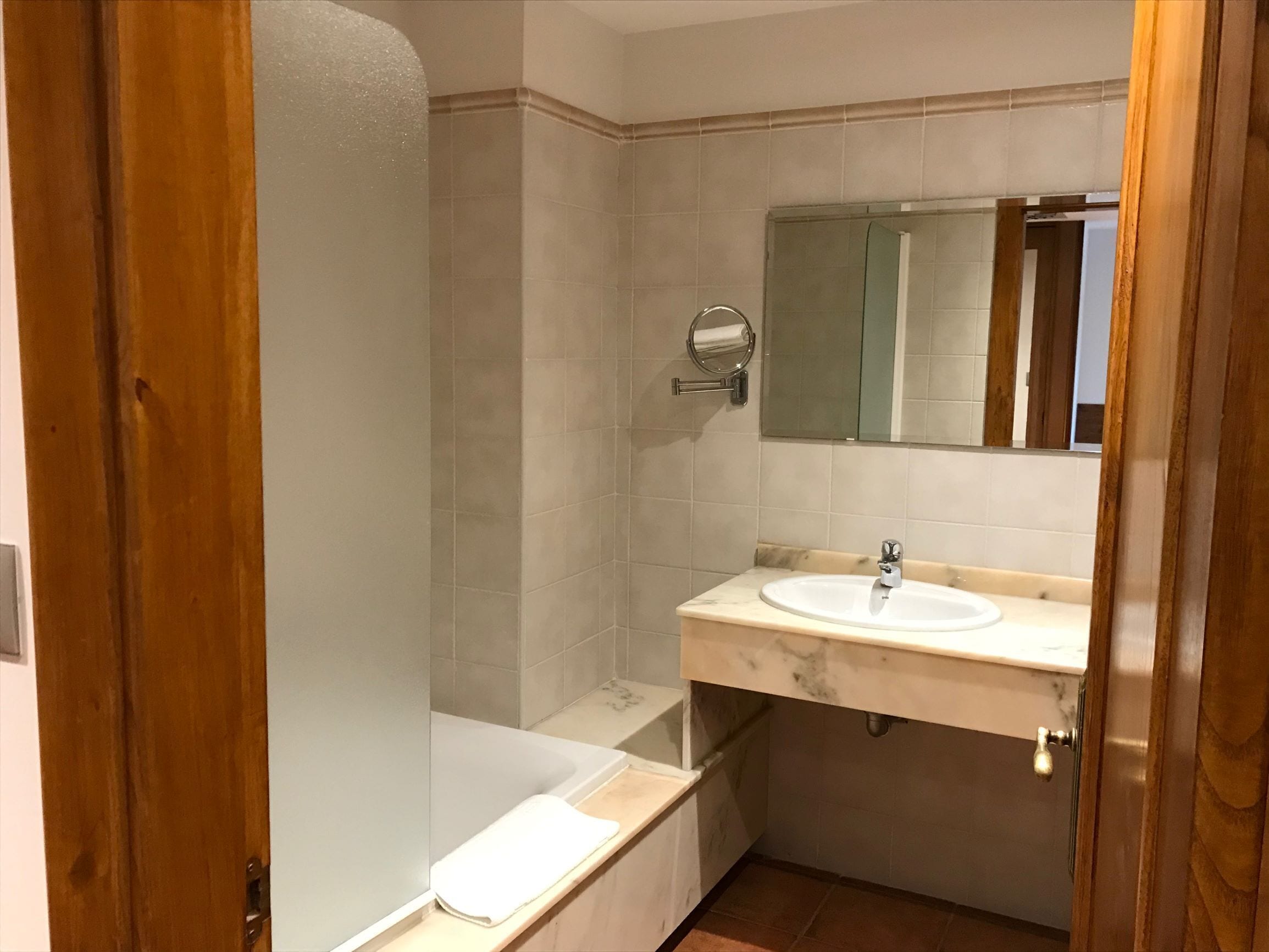 A bathroom with a bathtub, a sink, and a mirror.