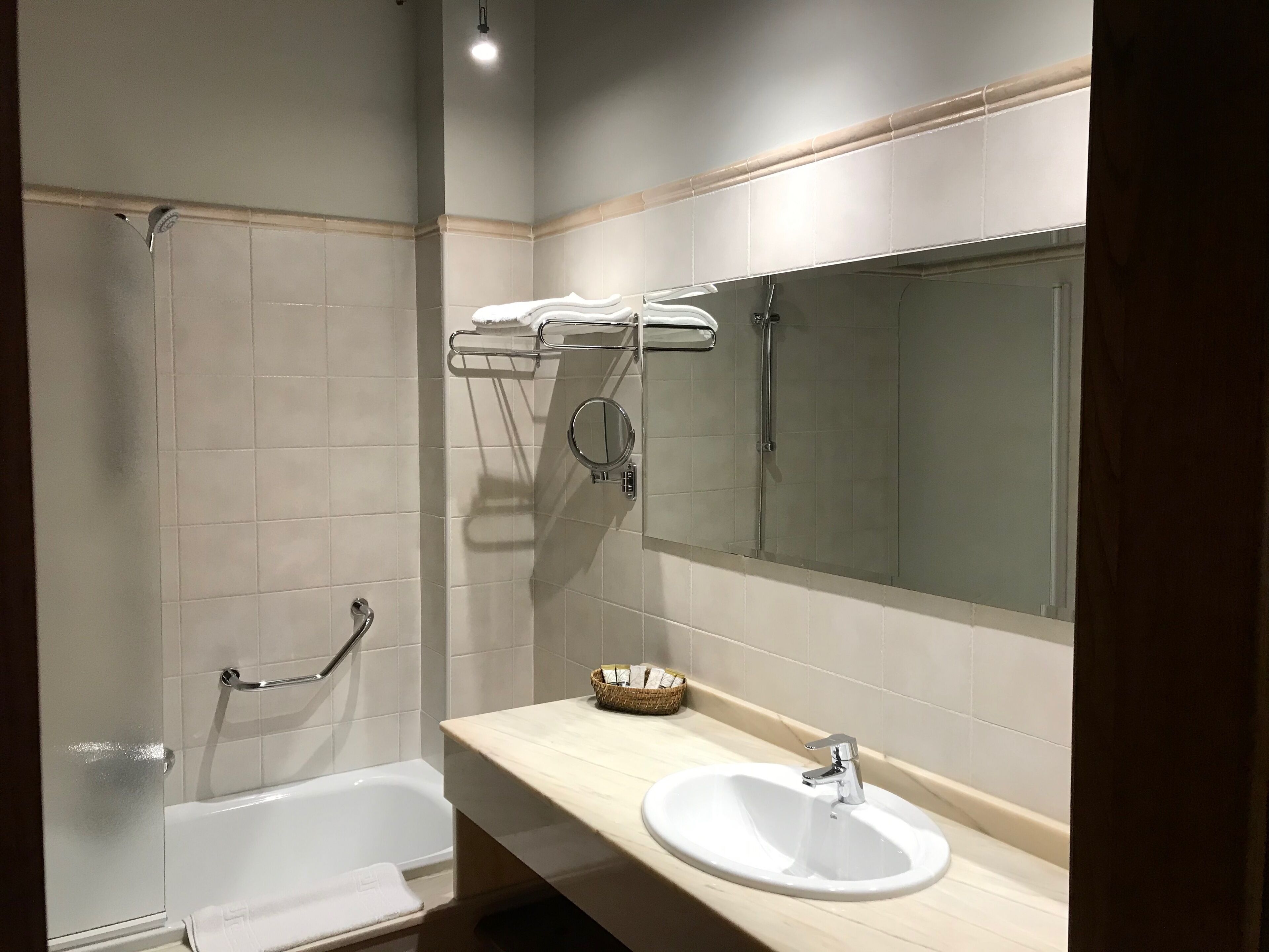 Une salle de bain moderne avec une baignoire, un lavabo, un miroir et une douche.