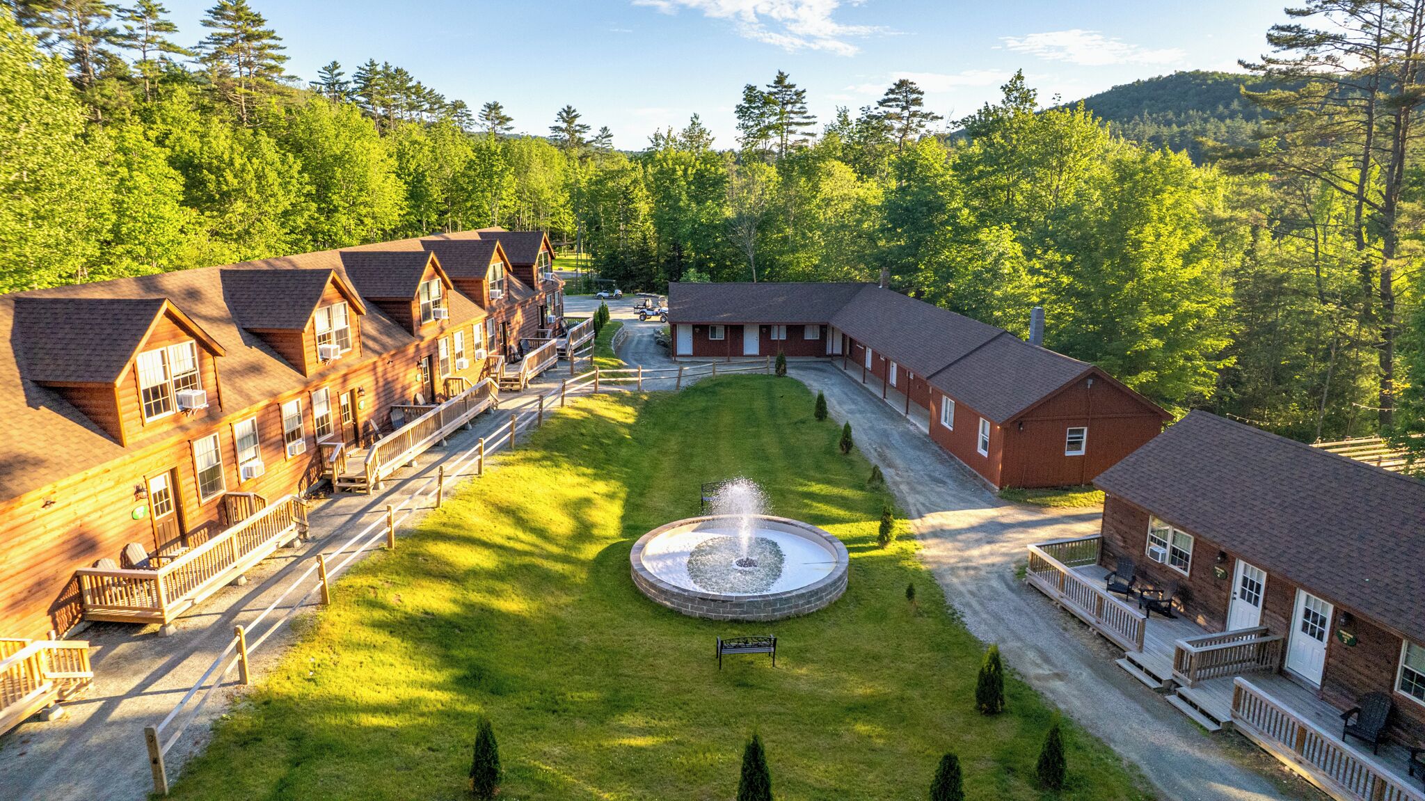 Un chalet doté de plusieurs cabanes, d’une fontaine centrale et d’une pelouse bien entretenue.