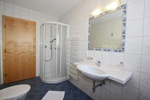 A bathroom with a toilet, a shower enclosure, a sink, and a mirror. - Apartment in Fiss Near Ski Lifts (Fiss)