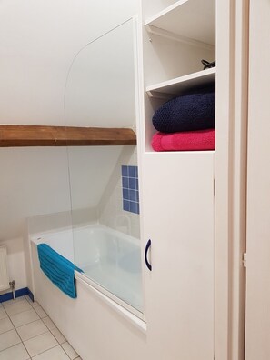 Een bad, een haardroger, handdoeken, toiletpapier