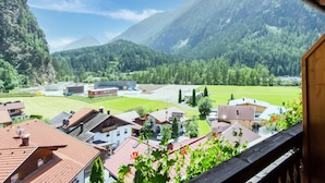 A residential area with houses, a green field, and mountains in the background. - Cozy Holiday Home in Tyrol near Ski Area (Oetz)