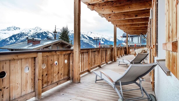 A wooden deck with lounge chairs overlooking a snowy mountain landscape. - Unique & Exclusively Furnished Chalet near Ski Lift (Mittersill)