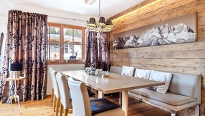 A dining area with a wooden table, chairs, and a bench. - Unique & Exclusively Furnished Chalet near Ski Lift (Mittersill)