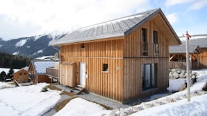 A wooden cabin with a sloped roof, a small porch, and a number sign indicating its location. - Lavish Wooded Chalet with Sauna & Hot Tub in Hohentauern (Hohentauern)