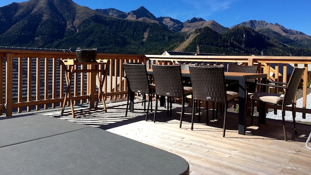 A wooden deck with outdoor seating and a mountain view. - Lavish Wooded Chalet with Sauna & Hot Tub in Hohentauern (Hohentauern)