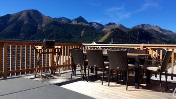 A wooden deck with outdoor seating and a mountain view.