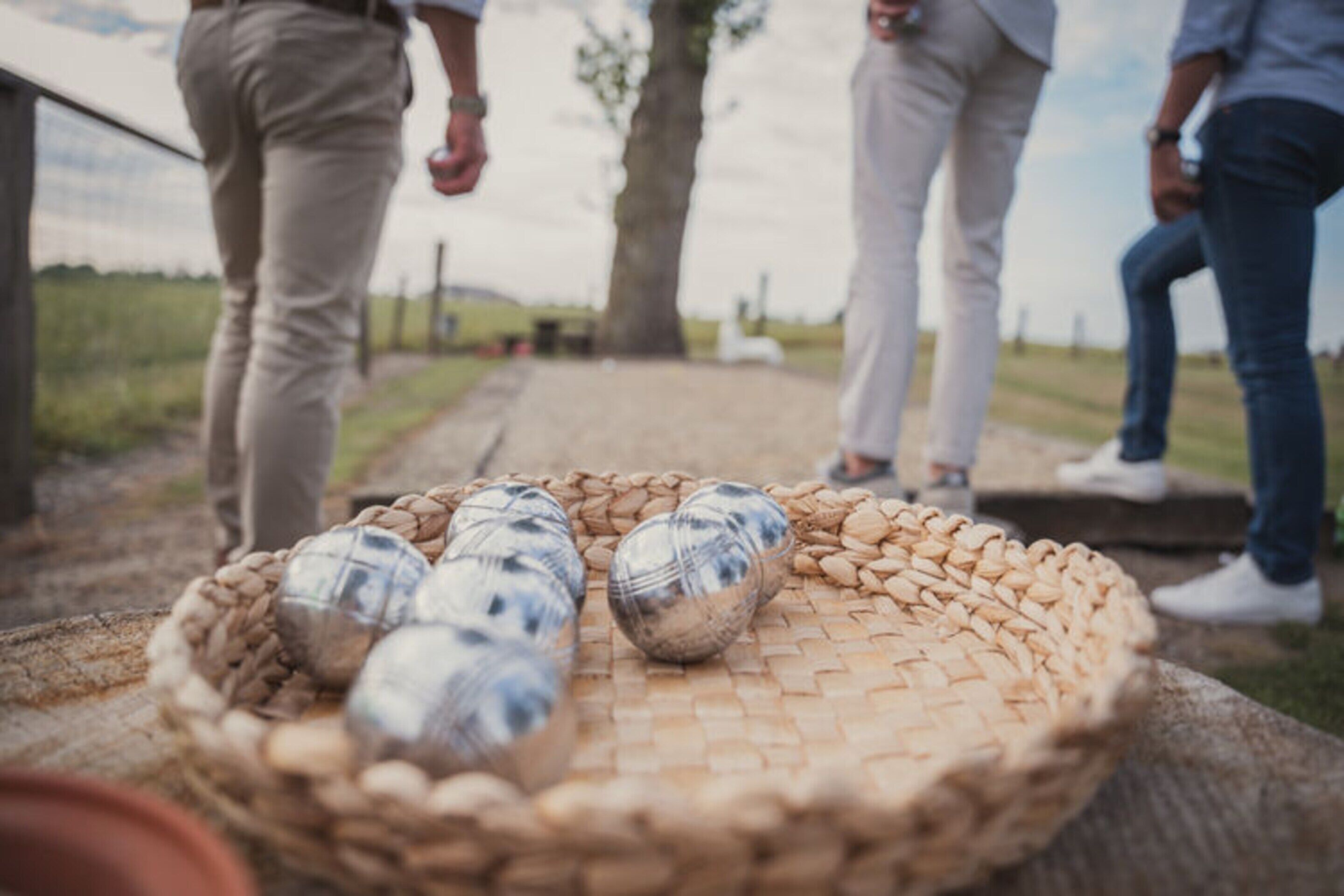 A basket of bottles on a woven mat.