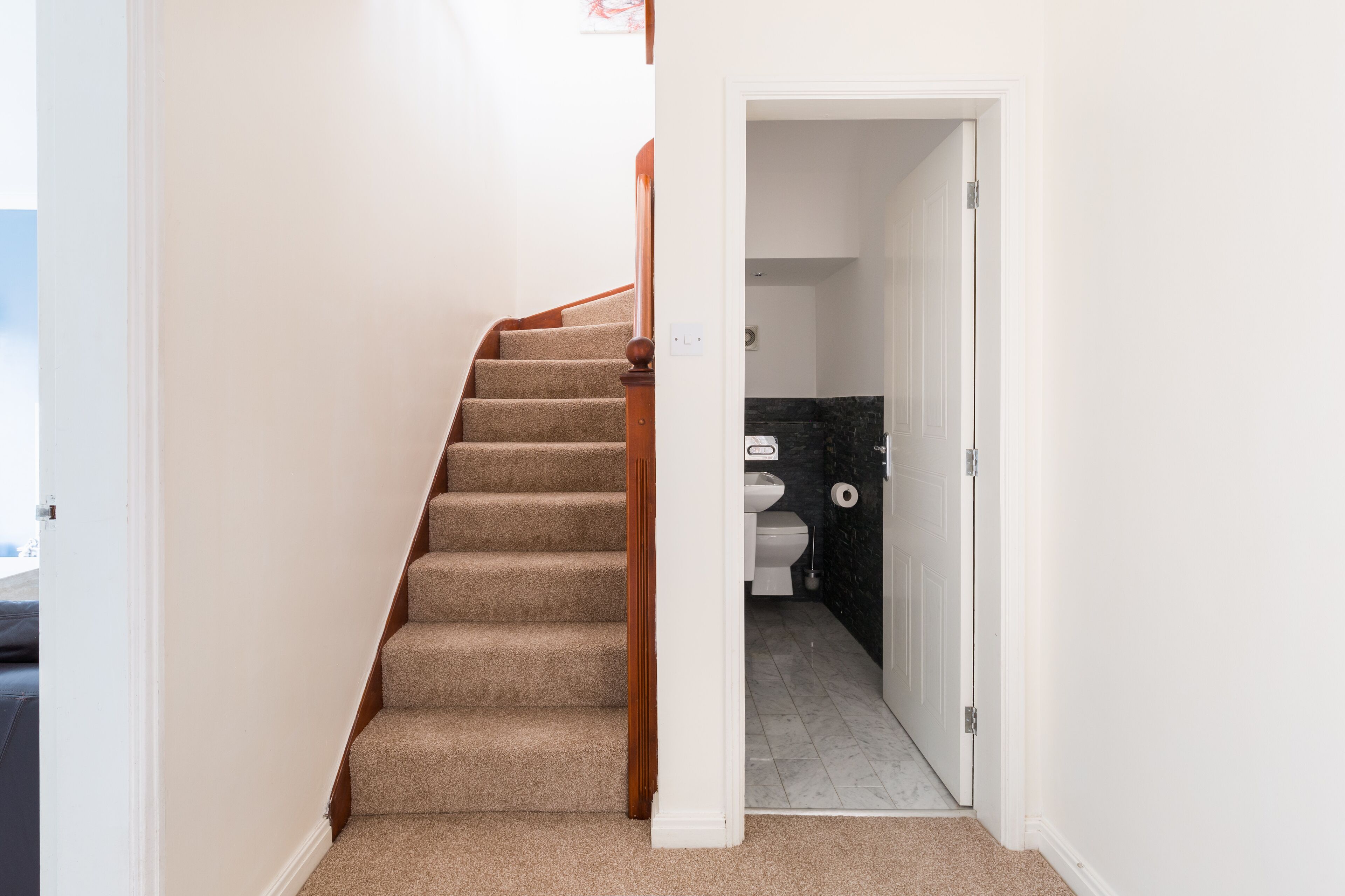 A staircase leading to a bathroom with a toilet and a sink.