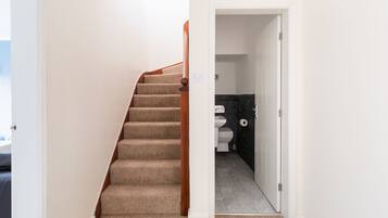 A staircase leading to a bathroom with a toilet and a sink.