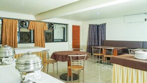 A dining area with tables, chairs, and a buffet setup. - Lals Plaza Hotel (Bhopal)