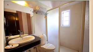 A bathroom with a double sink, a toilet, and a shower enclosure. - Lals Plaza Hotel (Bhopal)