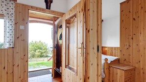 A wooden room with a bed, a small wooden cabinet, and a door leading outside. - Alpine Hut in Eberstein Near Ski Area (Eberstein)