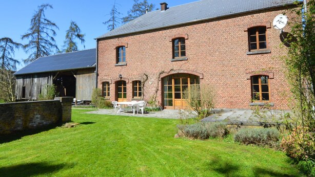 A brick building with a sloped roof, a large front door, and a small satellite dish on the roof. - Cottage With Tennis Court (Havelange)