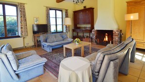 A living room with a fireplace, sofas, a television, and a bookshelf. - Cottage With Tennis Court (Havelange)