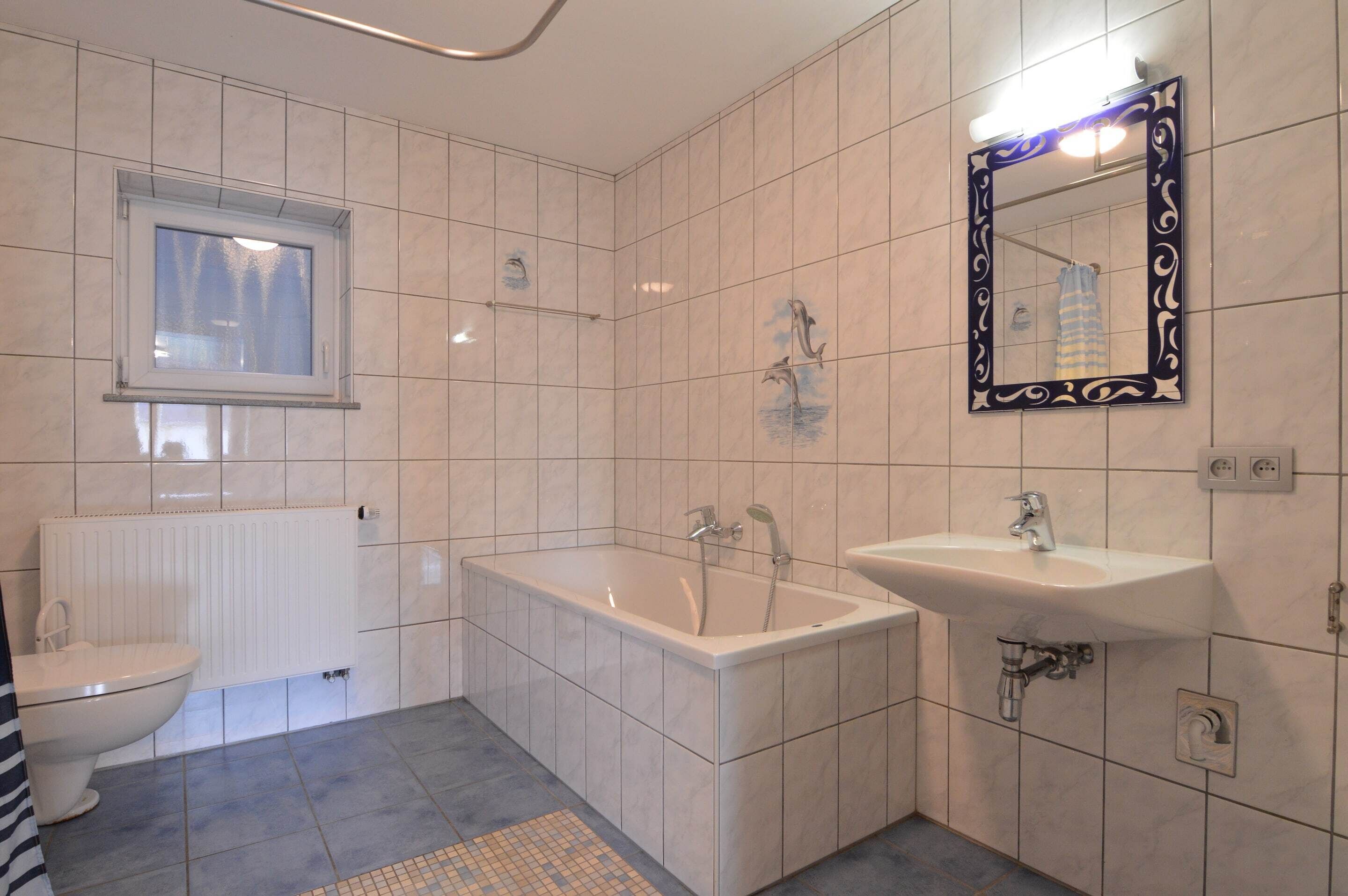 A modern bathroom with a bathtub, a sink, and a toilet.