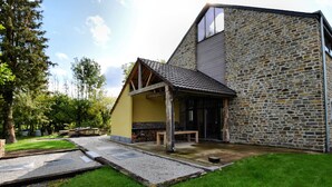 A modern house with a stone facade and a yellow exterior. - Pleasant Holiday Home in Erezée Ardennes with Hot Tub, Sauna (Erezee)