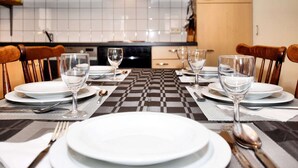 A dining area with a checkered tablecloth, white plates, and wine glasses set for four. - Nice Apartments in a Monumental Square Farm (Vise)