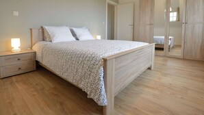 A bedroom with a wooden bed, bedside tables, a wardrobe, and a mirror. - Sint-amands Country Escape (Puurs-Sint-Amands)